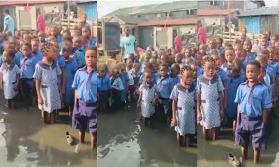 School pupils recite National Anthem inside muddy water