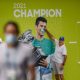 A spectator places a mask over the face of Novak Djokovic on a billboard at Melbourne Park.