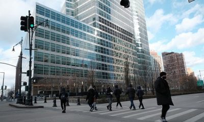 Major NYC employers are setting February dates for staff to return to work in person, as COVID-19 cases continue dropping. Above, pedestrians walk outside a seemingly deserted Goldman Sachs building in lower Manhattan on January 18